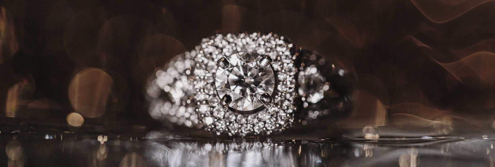 Diamond halo ring photographed against warm lights