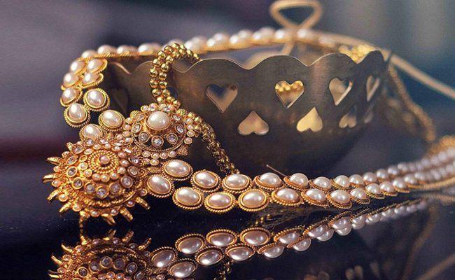 Pearl and gold necklace on a dark surface