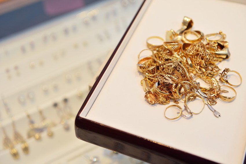 A tray of unwanted gold rings and chains on the counter